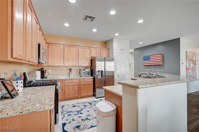 7460 Chaffinch St, North Las Vegas, NV 89084 - kitchen featuring stainless steel appliances, light brown cabinets, light stone counters, and recessed lighting