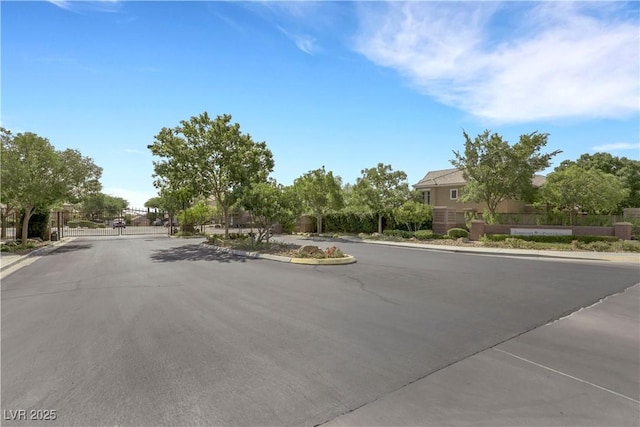 7125 Silver Ridge Peak St, Las Vegas, NV 89166 - view of asphalt road featuring curbs, a gated entry, and a gate