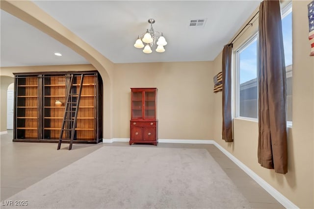 7125 Silver Ridge Peak St, Las Vegas, NV 89166 - carpeted empty room with arched walkways and a chandelier