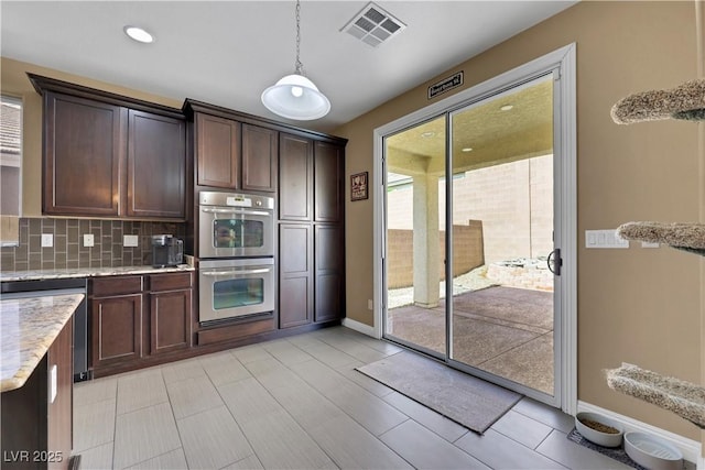 7125 Silver Ridge Peak St, Las Vegas, NV 89166 - kitchen with stainless steel double oven, dark brown cabinets, tasteful backsplash, light stone countertops, and decorative light fixtures