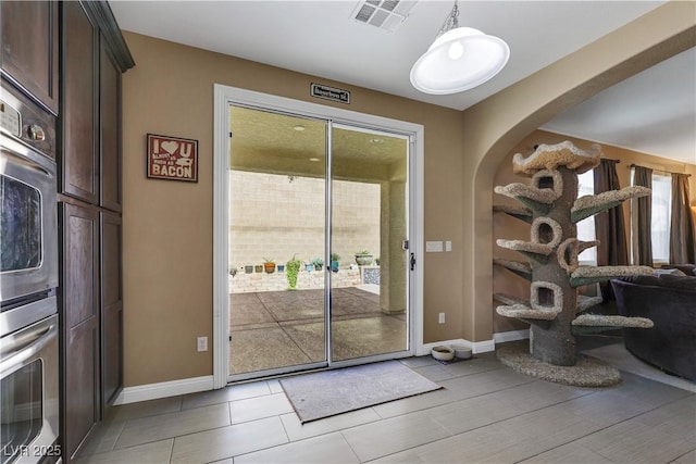 7125 Silver Ridge Peak St, Las Vegas, NV 89166 - doorway to outside featuring arched walkways and baseboards