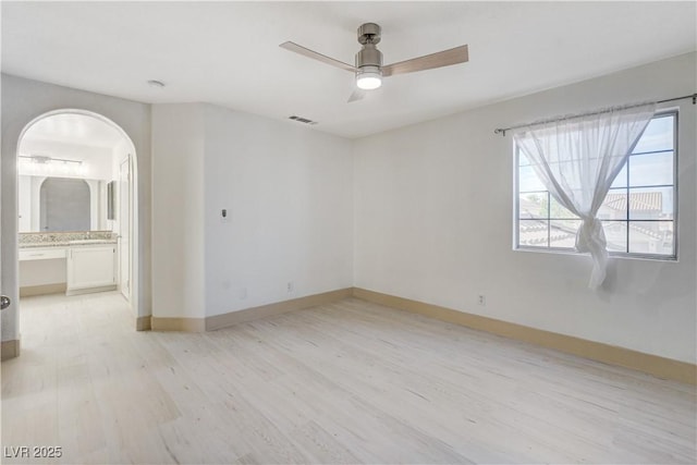 9409 Hershey Ln, Las Vegas, NV 89134 - unfurnished room featuring light wood-style floors, a ceiling fan, and arched walkways