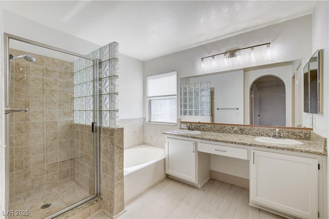 9409 Hershey Ln, Las Vegas, NV 89134 - full bathroom featuring a bath, double vanity, a stall shower, and wood finished floors