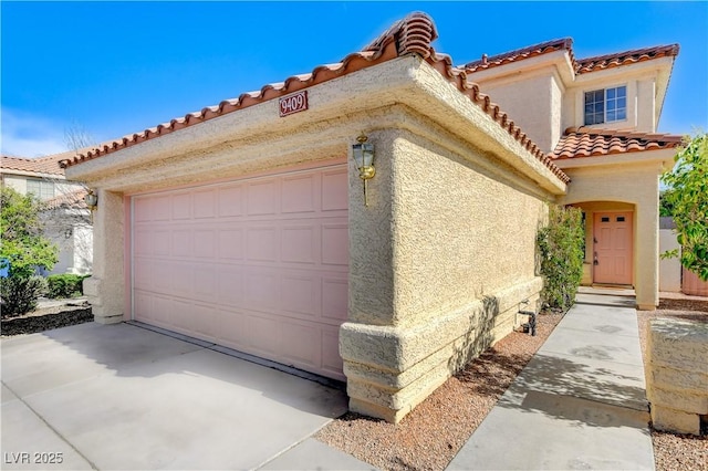 9409 Hershey Ln, Las Vegas, NV 89134 - view of front of property with a tiled roof, stucco siding, and an attached garage