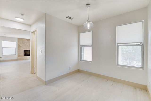 9409 Hershey Ln, Las Vegas, NV 89134 - empty room with light wood-style flooring, a smoke detector, and a premium fireplace