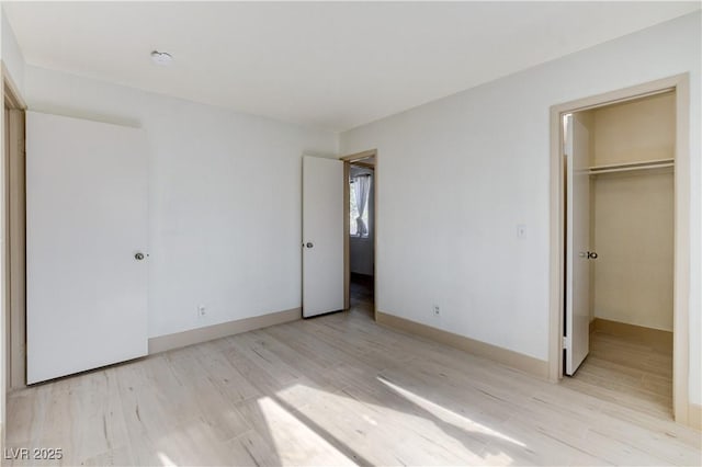 9409 Hershey Ln, Las Vegas, NV 89134 - unfurnished bedroom with light wood-type flooring, a spacious closet, and a closet