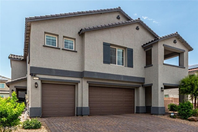 7615 Quail Dust St, North Las Vegas, NV 89084 - view of front of home with stucco siding, an attached garage, a tiled roof, and decorative driveway