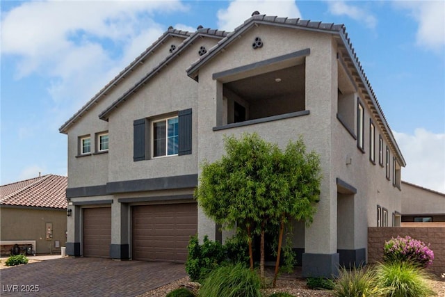 7615 Quail Dust St, North Las Vegas, NV 89084 - view of front of home with stucco siding, an attached garage, and decorative driveway