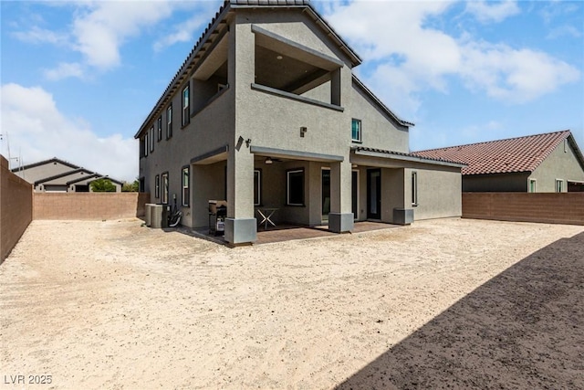 7615 Quail Dust St, North Las Vegas, NV 89084 - rear view of house with stucco siding, a patio area, and a fenced backyard