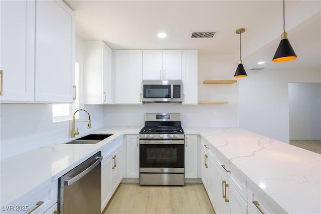 119 Cedar St, Henderson, NV 89015 - kitchen with appliances with stainless steel finishes, white cabinetry, open shelves, light wood-style flooring, and light stone countertops