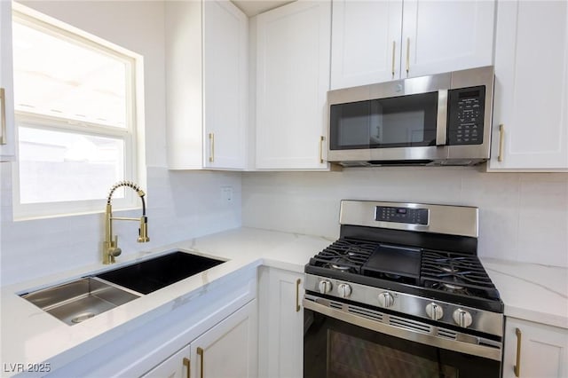 119 Cedar St, Henderson, NV 89015 - kitchen with appliances with stainless steel finishes, backsplash, white cabinetry, and light stone counters
