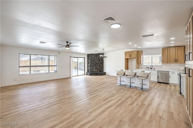 4616 Eureka St, Las Vegas, NV 89103 - unfurnished living room featuring a stone fireplace, light wood-style floors, a ceiling fan, and recessed lighting