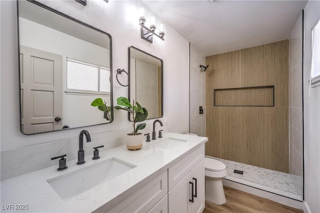 4616 Eureka St, Las Vegas, NV 89103 - bathroom featuring a tile shower, double vanity, and wood finished floors