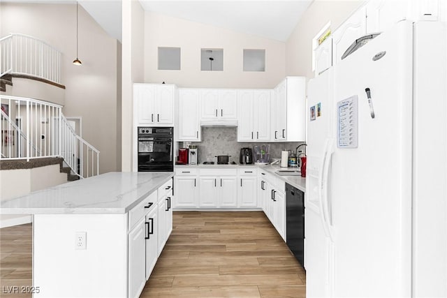 24 Staghorn St, Henderson, NV 89012 - kitchen featuring black appliances, high vaulted ceiling, tasteful backsplash, under cabinet range hood, and light wood finished floors