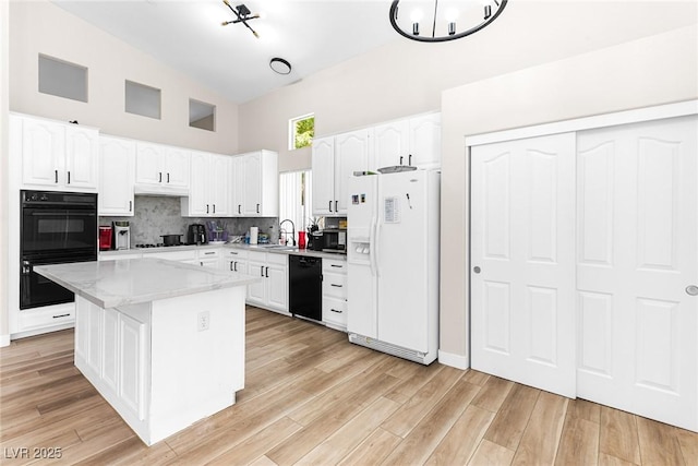 24 Staghorn St, Henderson, NV 89012 - kitchen featuring black appliances, high vaulted ceiling, white cabinetry, and under cabinet range hood