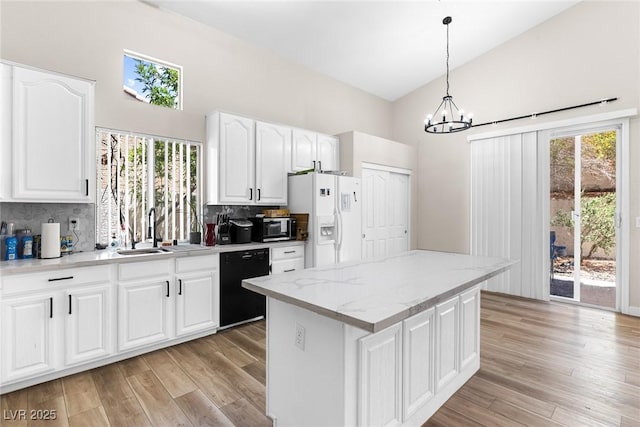 24 Staghorn St, Henderson, NV 89012 - kitchen featuring dishwasher, white fridge with ice dispenser, high vaulted ceiling, stainless steel microwave, and plenty of natural light
