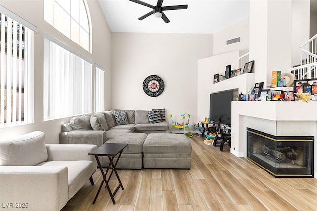 24 Staghorn St, Henderson, NV 89012 - living room with a towering ceiling, a ceiling fan, light wood-style floors, and a premium fireplace