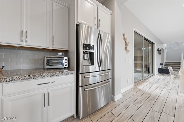 367 Pollino Peaks St, Las Vegas, NV 89138 - kitchen with stainless steel fridge, white cabinetry, wood finish floors, light stone counters, and backsplash