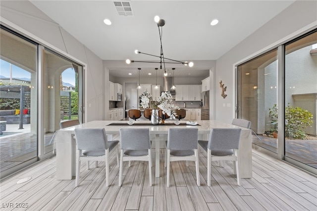 367 Pollino Peaks St, Las Vegas, NV 89138 - kitchen with white cabinets, a kitchen breakfast bar, a large island, stainless steel appliances, and a chandelier