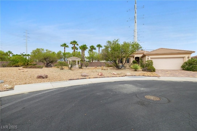 4126 Cascada Piazza Ln, Las Vegas, NV 89135 - view of front of property featuring a garage, driveway, a tiled roof, and stucco siding
