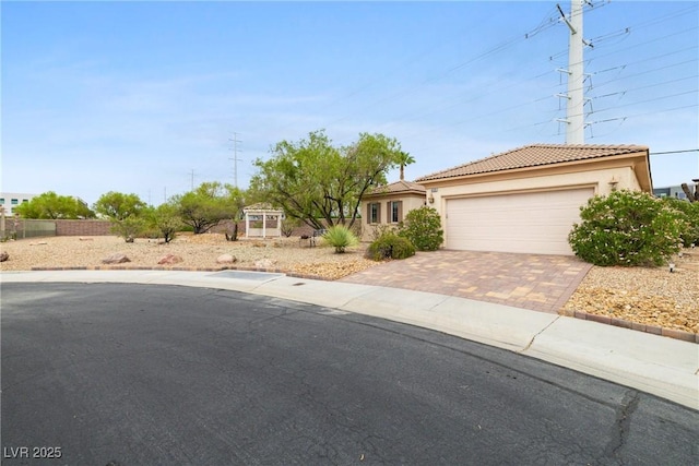 4126 Cascada Piazza Ln, Las Vegas, NV 89135 - view of front of home featuring decorative driveway, a tiled roof, an attached garage, and stucco siding