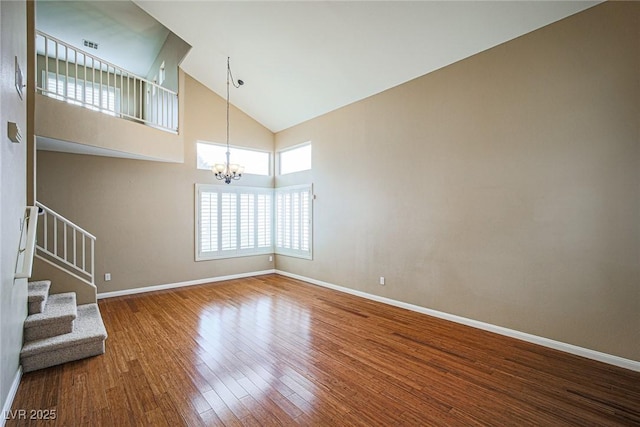 10204 Waseca Ave, Las Vegas, NV 89144 - unfurnished living room with a chandelier, wood finished floors, stairway, and high vaulted ceiling
