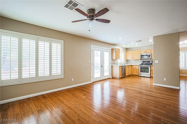 10204 Waseca Ave, Las Vegas, NV 89144 - kitchen with stainless steel appliances, light brown cabinets, wood finished floors, light countertops, and decorative backsplash