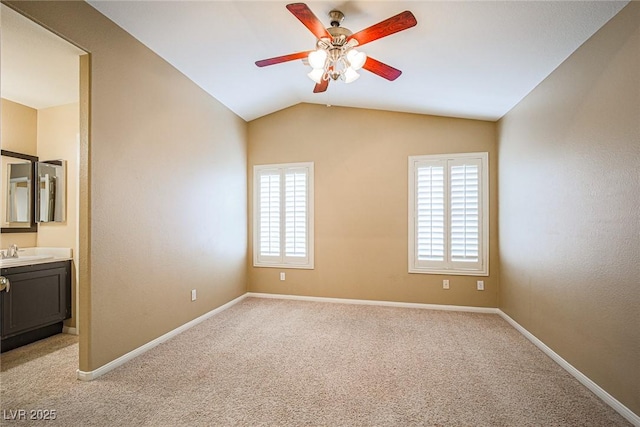10204 Waseca Ave, Las Vegas, NV 89144 - unfurnished bedroom featuring multiple windows, light carpet, vaulted ceiling, ensuite bathroom, and a ceiling fan