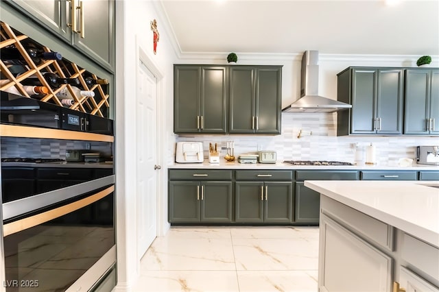 6209 Gambetta St, Las Vegas, NV 89115 - kitchen with wall chimney exhaust hood, light marble finish floors, light countertops, stainless steel gas cooktop, and crown molding