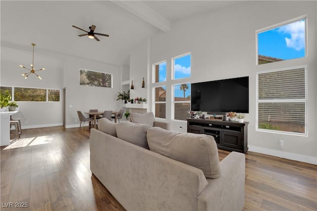 9089 Harvest Season Ct, Henderson, NV 89074 - living area with high vaulted ceiling, a chandelier, beam ceiling, wood finished floors, and ceiling fan