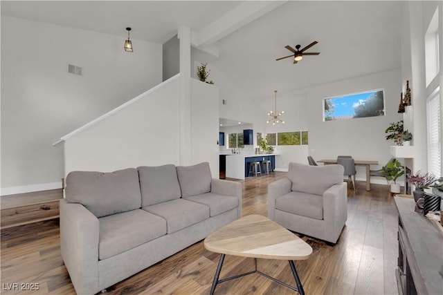 9089 Harvest Season Ct, Henderson, NV 89074 - living room with high vaulted ceiling, a chandelier, ceiling fan, beam ceiling, and wood finished floors