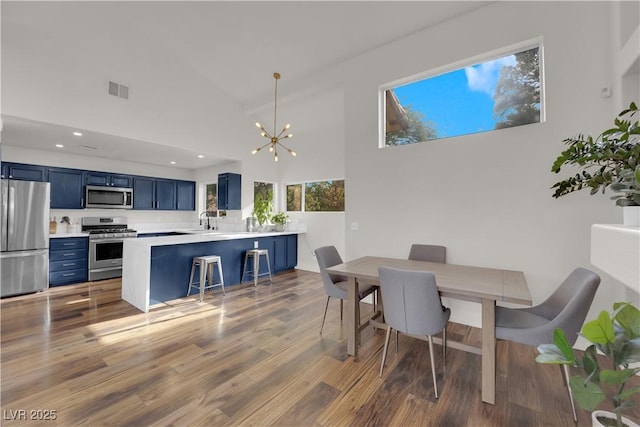 9089 Harvest Season Ct, Henderson, NV 89074 - dining space with a chandelier, wood finished floors, a towering ceiling, and recessed lighting