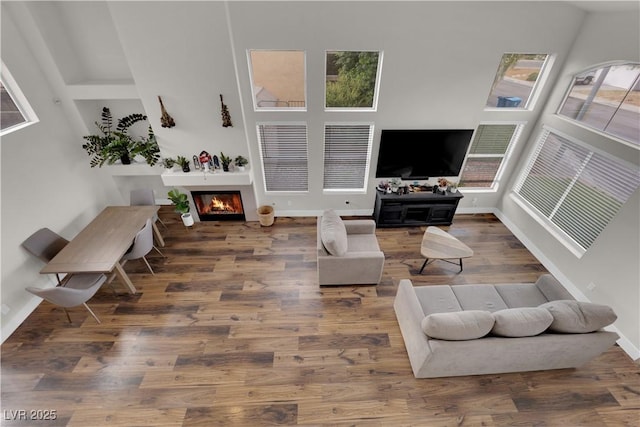9089 Harvest Season Ct, Henderson, NV 89074 - living area featuring a glass covered fireplace, wood finished floors, and plenty of natural light