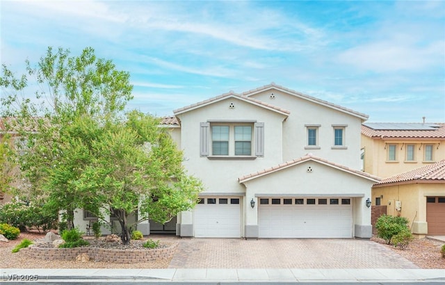 6937 Puetollano Dr, North Las Vegas, NV 89084 - mediterranean / spanish-style home featuring an attached garage, stucco siding, a tile roof, and decorative driveway
