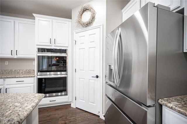6937 Puetollano Dr, North Las Vegas, NV 89084 - kitchen featuring appliances with stainless steel finishes, white cabinets, dark wood-type flooring, and light stone countertops