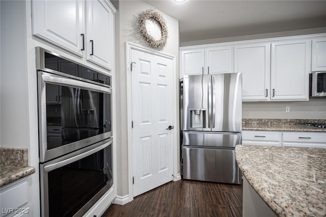 6937 Puetollano Dr, North Las Vegas, NV 89084 - kitchen featuring appliances with stainless steel finishes, white cabinetry, dark wood finished floors, and light stone countertops