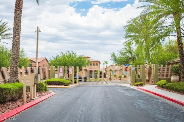 6937 Puetollano Dr, North Las Vegas, NV 89084 - view of asphalt street with a gate, curbs, a residential view, and a gated entry
