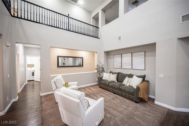 6937 Puetollano Dr, North Las Vegas, NV 89084 - living area featuring washing machine and clothes dryer, a towering ceiling, and wood finished floors