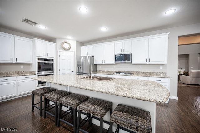 6937 Puetollano Dr, North Las Vegas, NV 89084 - kitchen featuring appliances with stainless steel finishes, a breakfast bar area, white cabinetry, and recessed lighting