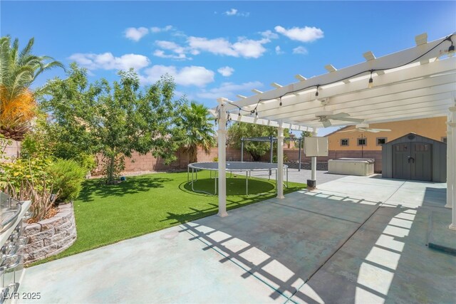 2912 Hot Cider Ave, North Las Vegas, NV 89031 - fenced backyard featuring a trampoline, a patio, a storage shed, ceiling fan, and a hot tub