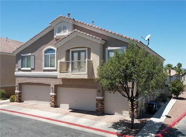 1073 Pleasure Ln Unit 2, Henderson, NV 89002 - view of property featuring stone siding, an attached garage, stucco siding, and a balcony