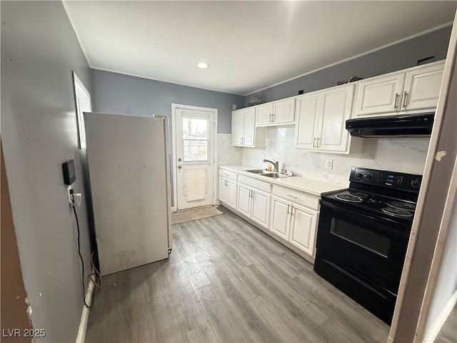 15 Washington Way, Henderson, NV 89015 - kitchen featuring black / electric stove, under cabinet range hood, freestanding refrigerator, light countertops, and white cabinetry