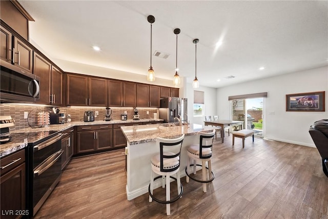 3603 E Umatilla Ave, Pahrump, NV 89061 - kitchen featuring stainless steel appliances, dark brown cabinets, wood finished floors, backsplash, and recessed lighting