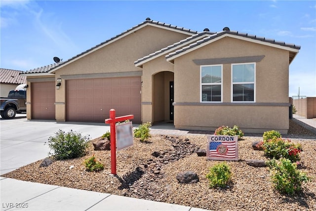 3603 E Umatilla Ave, Pahrump, NV 89061 - view of front of home with a garage, driveway, stucco siding, and a tile roof