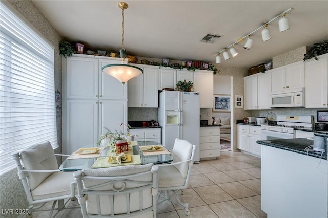 7836 Silver Plateau Ave, Las Vegas, NV 89128 - kitchen with white appliances, dark countertops, healthy amount of natural light, and white cabinets