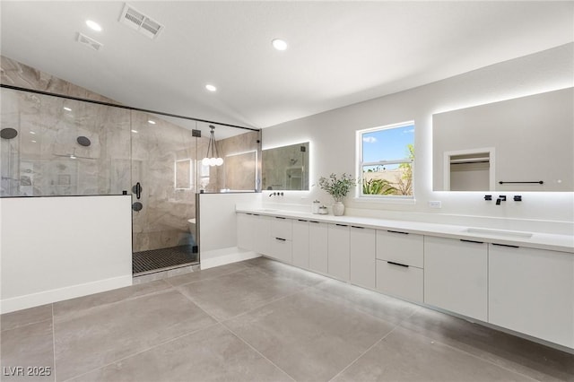 10707 Sleepy Mist Ct, Las Vegas, NV 89141 - bathroom with double vanity, a stall shower, recessed lighting, finished concrete flooring, and vaulted ceiling