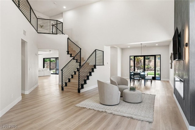 10707 Sleepy Mist Ct, Las Vegas, NV 89141 - living room with a towering ceiling, stairs, and light wood-type flooring