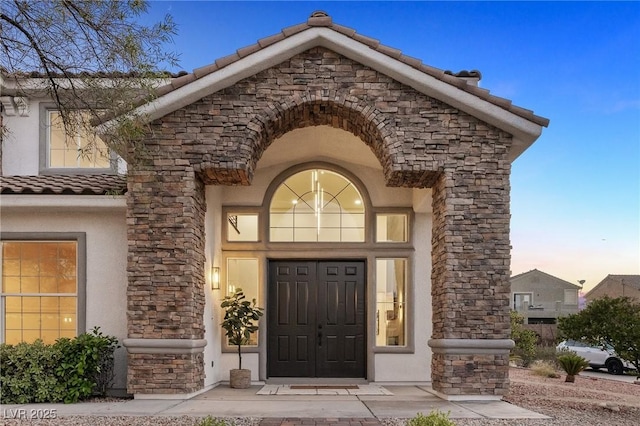 10707 Sleepy Mist Ct, Las Vegas, NV 89141 - view of exterior entry featuring stone siding, a tiled roof, and stucco siding