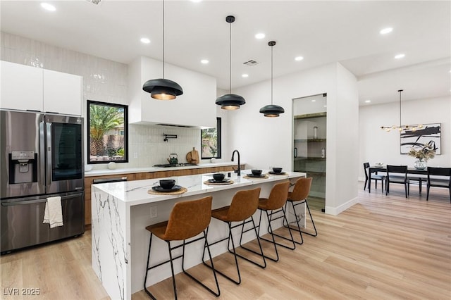 10707 Sleepy Mist Ct, Las Vegas, NV 89141 - kitchen with stainless steel fridge with ice dispenser, white cabinets, modern cabinets, an island with sink, and recessed lighting