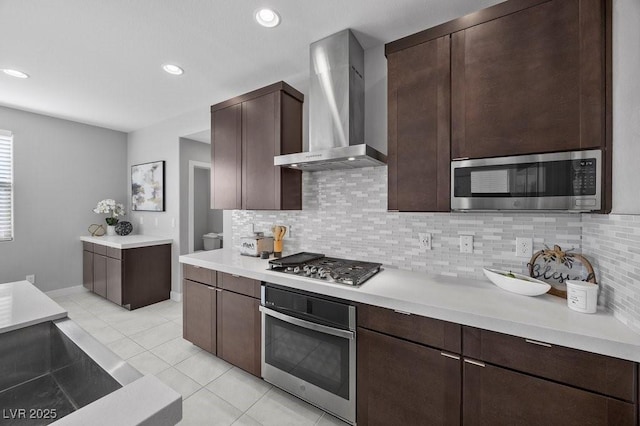 635 Pyrite Will St, Las Vegas, NV 89138 - kitchen featuring stainless steel appliances, wall chimney exhaust hood, light countertops, backsplash, and light tile patterned floors